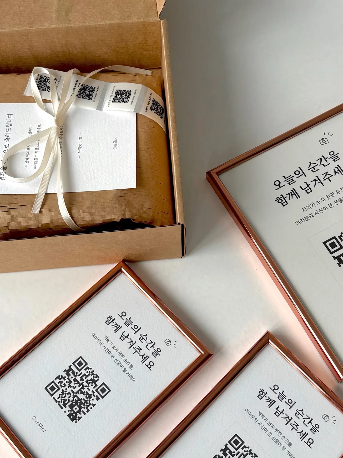 아워샷 QR 액자와 스티커가 함께 놓인 QR 공유 패키지